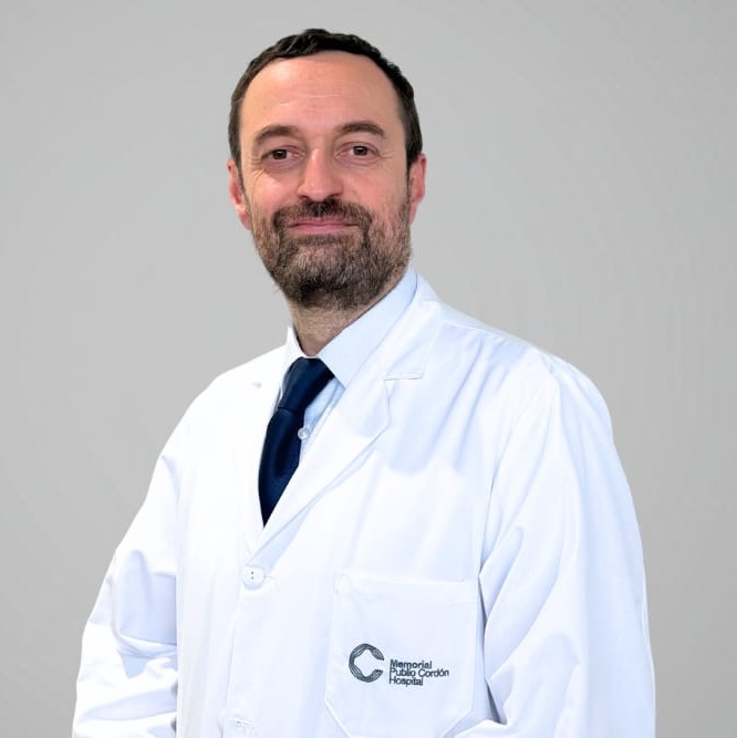 Dr. Francisco Mera, médico de familia, en bata blanca en un pasillo clínico